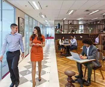 Coworking space in Servcorp were a receptionist is showing the client around. 