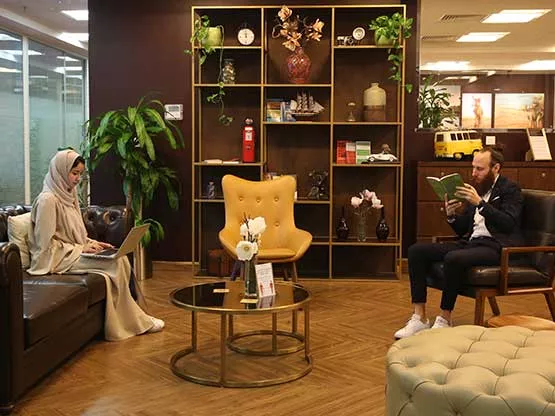 A Warm and inviting Servcorp business lounge, where two professionals are comfortably seated in a tastefully decorated space with elegant furnishings